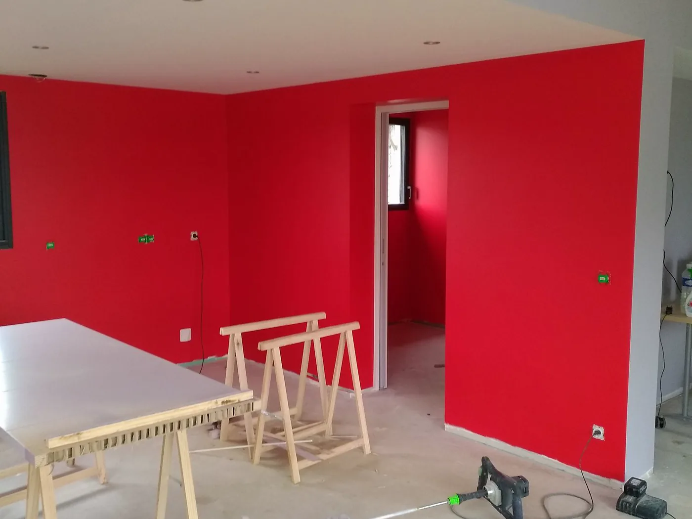 Mur peint en rouge dans une pièce à vivre à Saint-Jean-de-Bournay